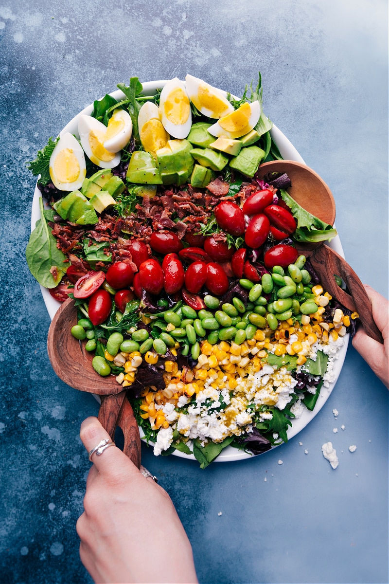 This is our favorite Cobb Salad complete with hard-boiled eggs, creamy avocado, crisp center-cut bacon, juicy cherry tomatoes, buttery edamame, sweet corn, and rich goat (or feta) cheese. Recipe via ChelseasMessyApron #dinner #side #best #healthy #whole #clean #cleaneating #keto #cobbsalad #herbed #vinaigrette Cobb Salad with an herbed vinaigrette