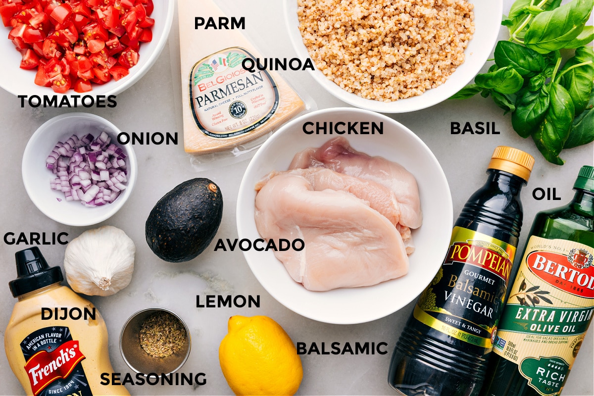 Ingredients In Bruschetta Chicken All the ingredients are prepped for easy assemblyโtomatoes, Parmesan, quinoa, basil, chicken, avocado, onion, garlic, Dijon, lemon, balsamic, and seasonings.