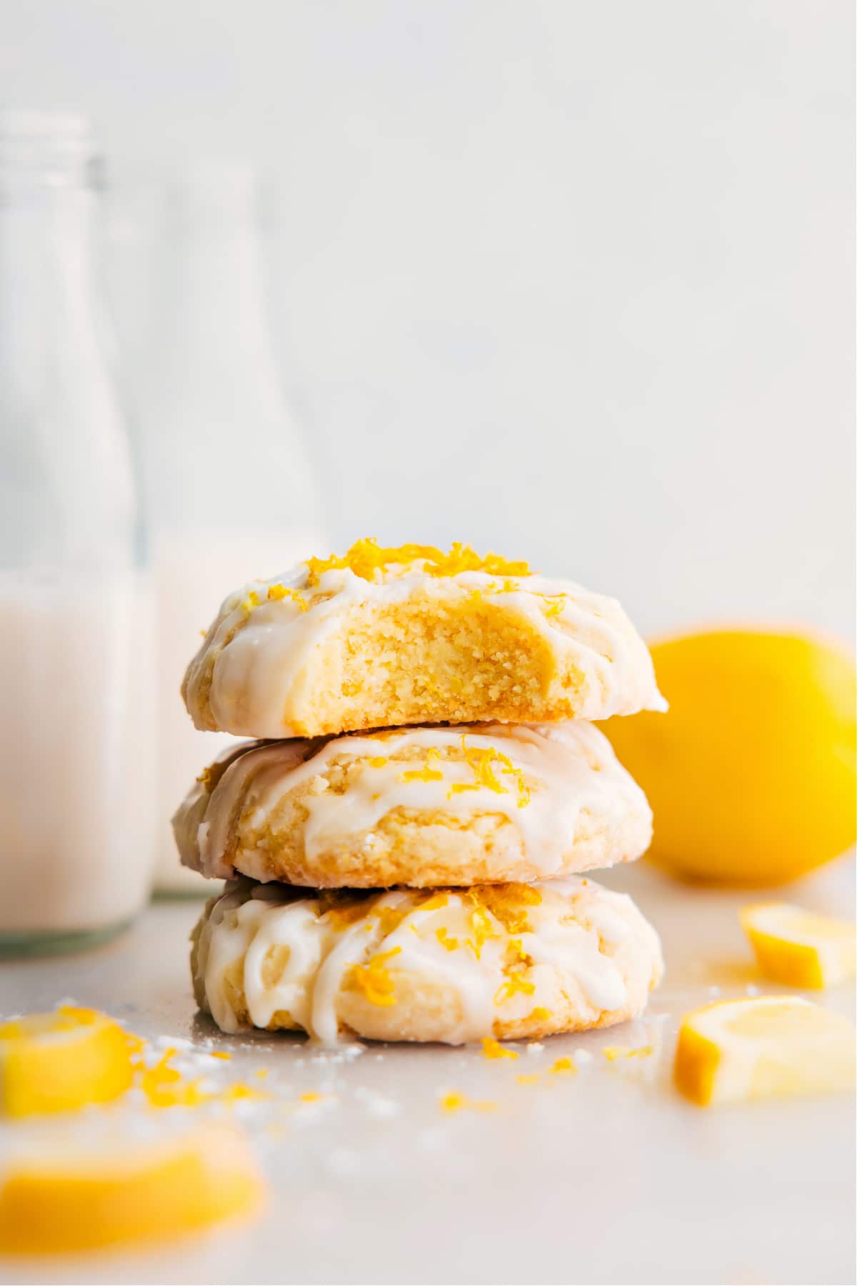 Lemon Cookies Recipe stacked on top of each other with a bite out of the top one.