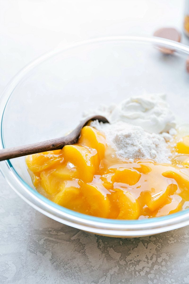 Mixing peaches with other ingredients The cake mix and peach pie filling being mixed together in a bowl for this peaches and cream cake.