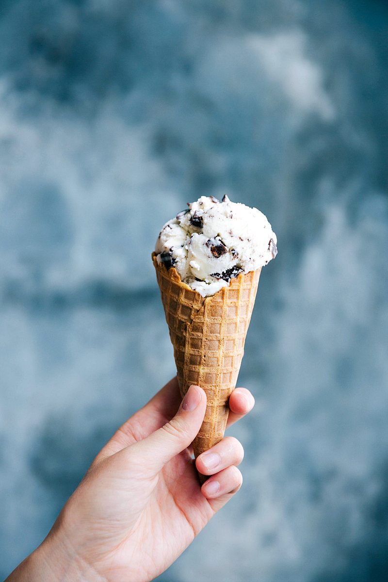 Stracciatella Gelato in Waffle Cone Stracciatella gelato in a waffle cone being held, ready to be enjoyed as a refreshing dessert.