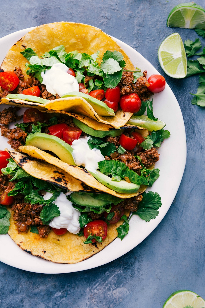 Delicious Turkey Tacos with Toppings and Fresh Lime Wedges, Ready for Enjoyment Tantalizing turkey tacos on a plate, adorned with toppings and accompanied by fresh lime wedges, eagerly awaiting to be savored.
