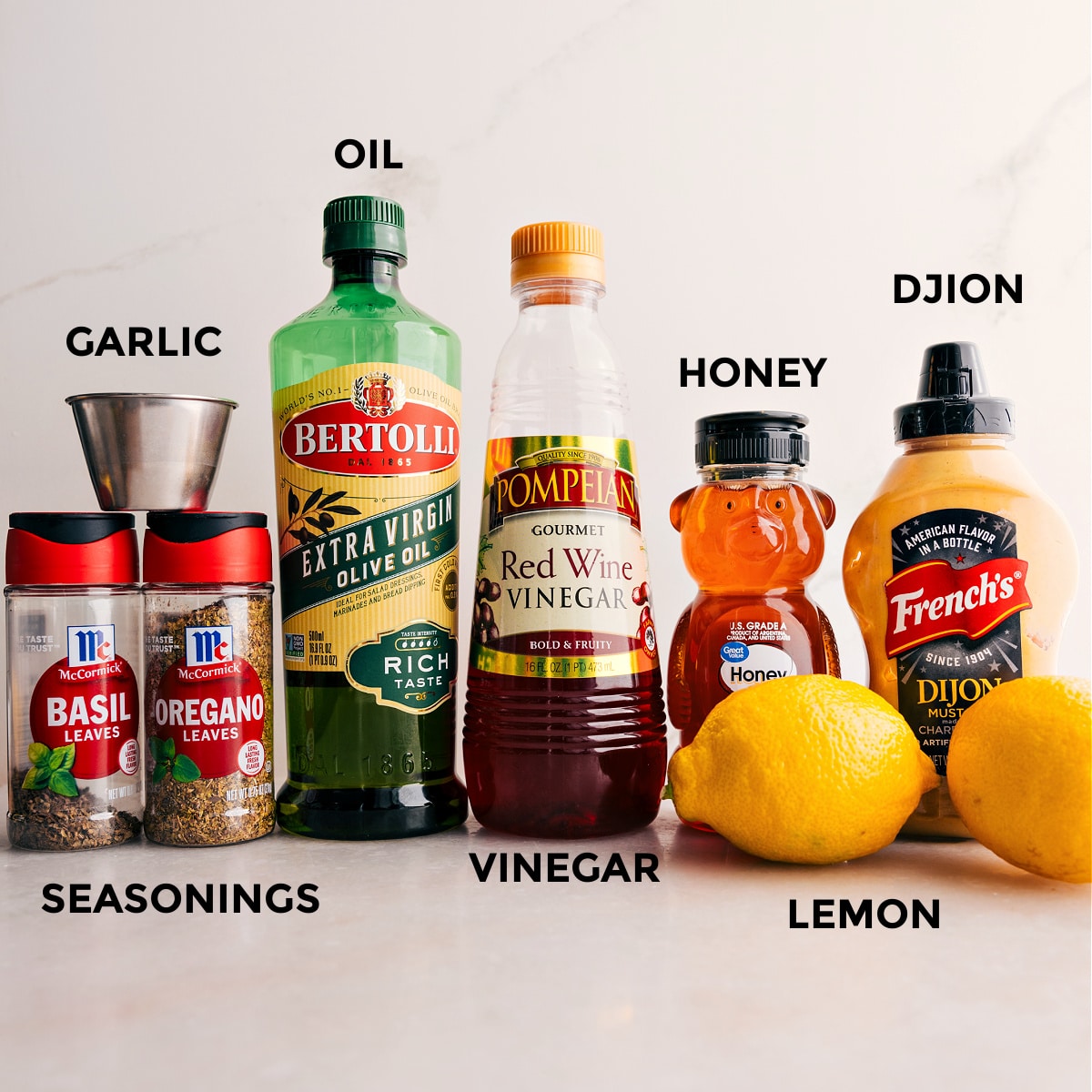 The Best Salad Dressing For Couscous Mediterranean Salad Dressing ingredients prepped for easy assembly: seasonings, oil, mustard, honey, lemon, and garlic.