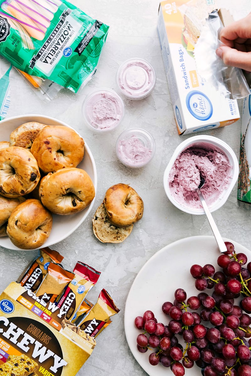 Healthy School Lunch Components A healthy school lunch, including bagels, string cheese, cream cheese, grapes, and granola bars, arranged for easy packing.