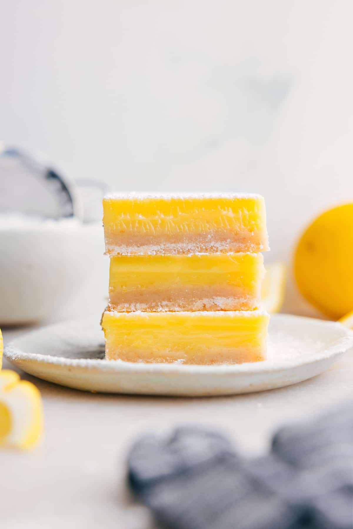 Lemon Bars stacked on top of each other, dusted with powdered sugar.