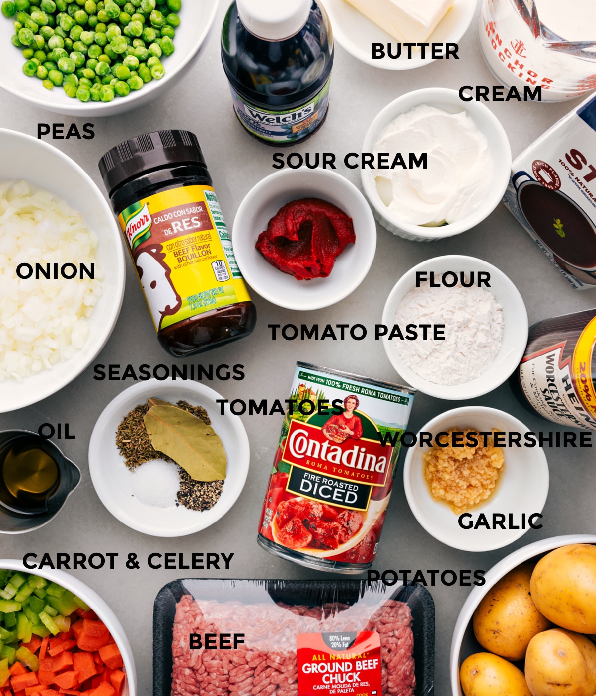 Ingredients In Ground Beef Shepherd's Pie All the ingredients in this recipe prepped out for easy assembly including the peas, onions, seasonings, tomatoes, sour cream, tomato paste, grape juice, butter, cream, stock, flour, Worcestershire, garlic, potatoes, and beef.