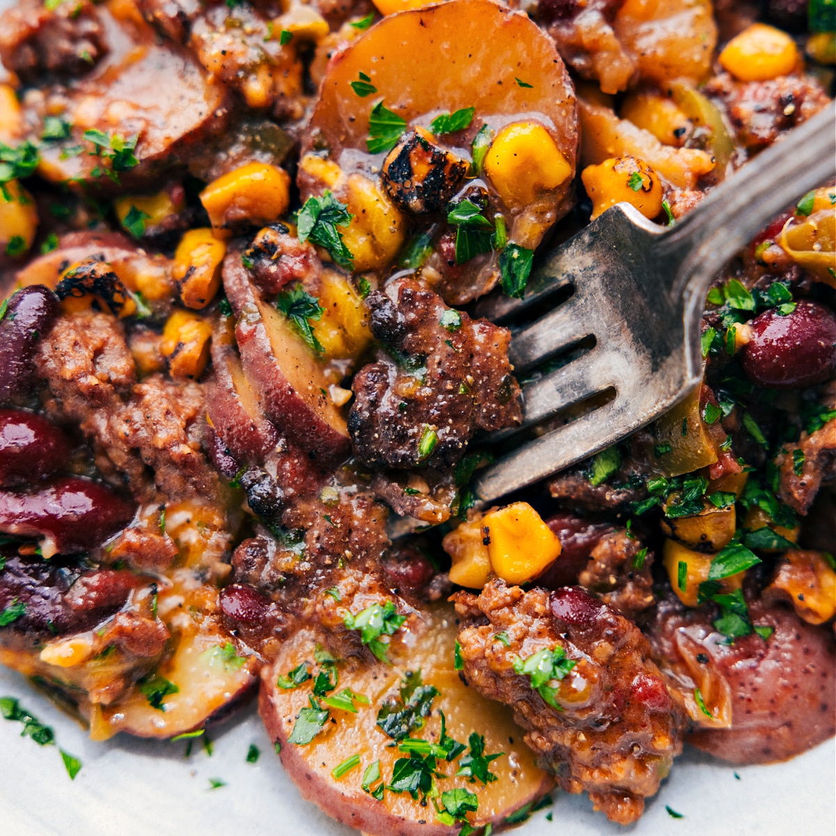 Enjoy The Best Slow Cooker Cowboy Casserole The completed dish on a plate with a big forkful.