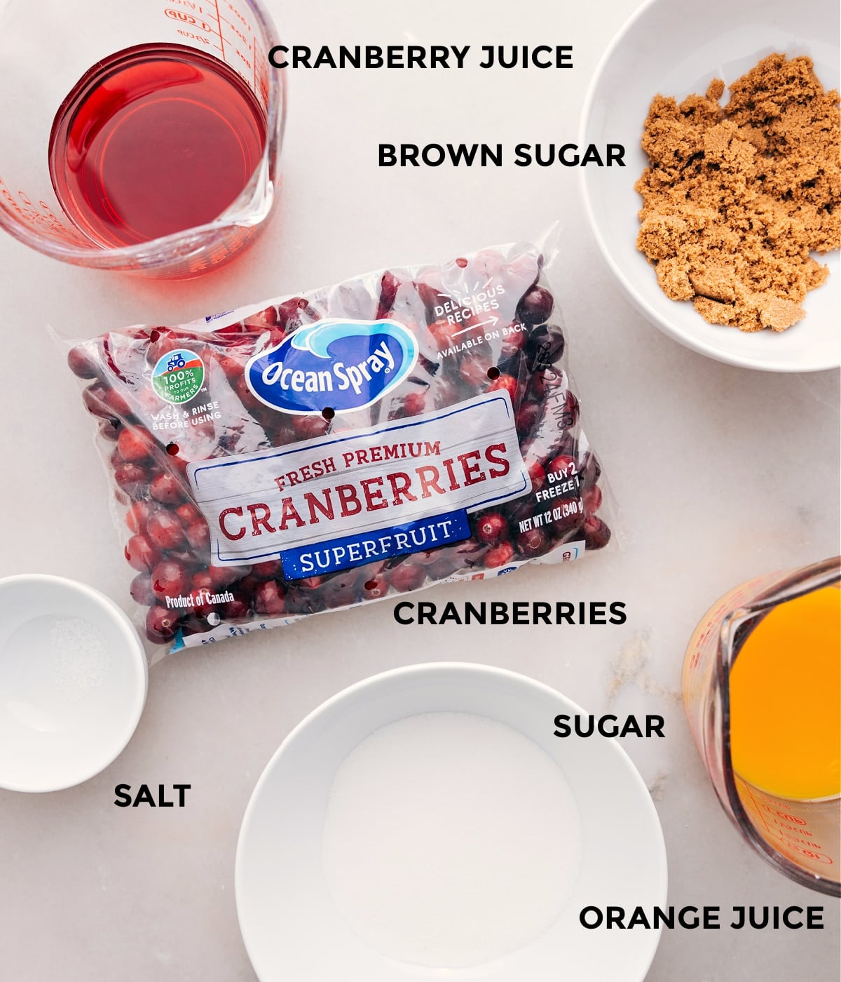 Ingredients In Cranberry Sauce This recipe's ingredients are prepped for easy assembly: cranberries, sugar, orange juice, brown sugar, cranberry juice, and salt.