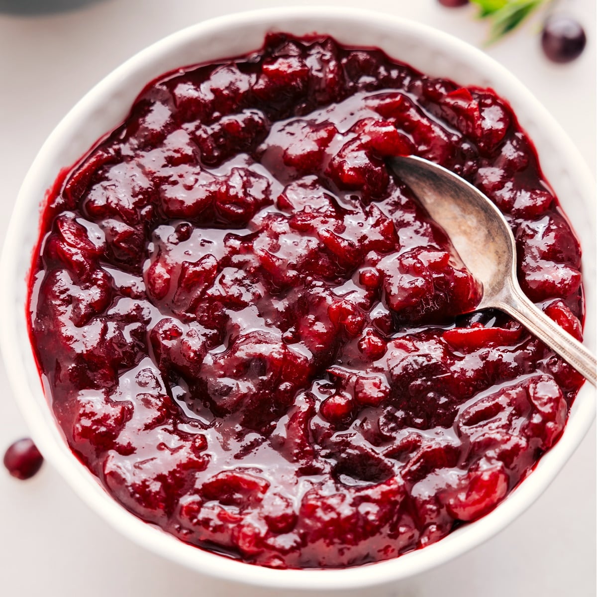 The Ultimate Holiday Spread: Cranberry Sauce Cranberry sauce in a bowl with a spoon, ready to serve alongside your holiday turkey.