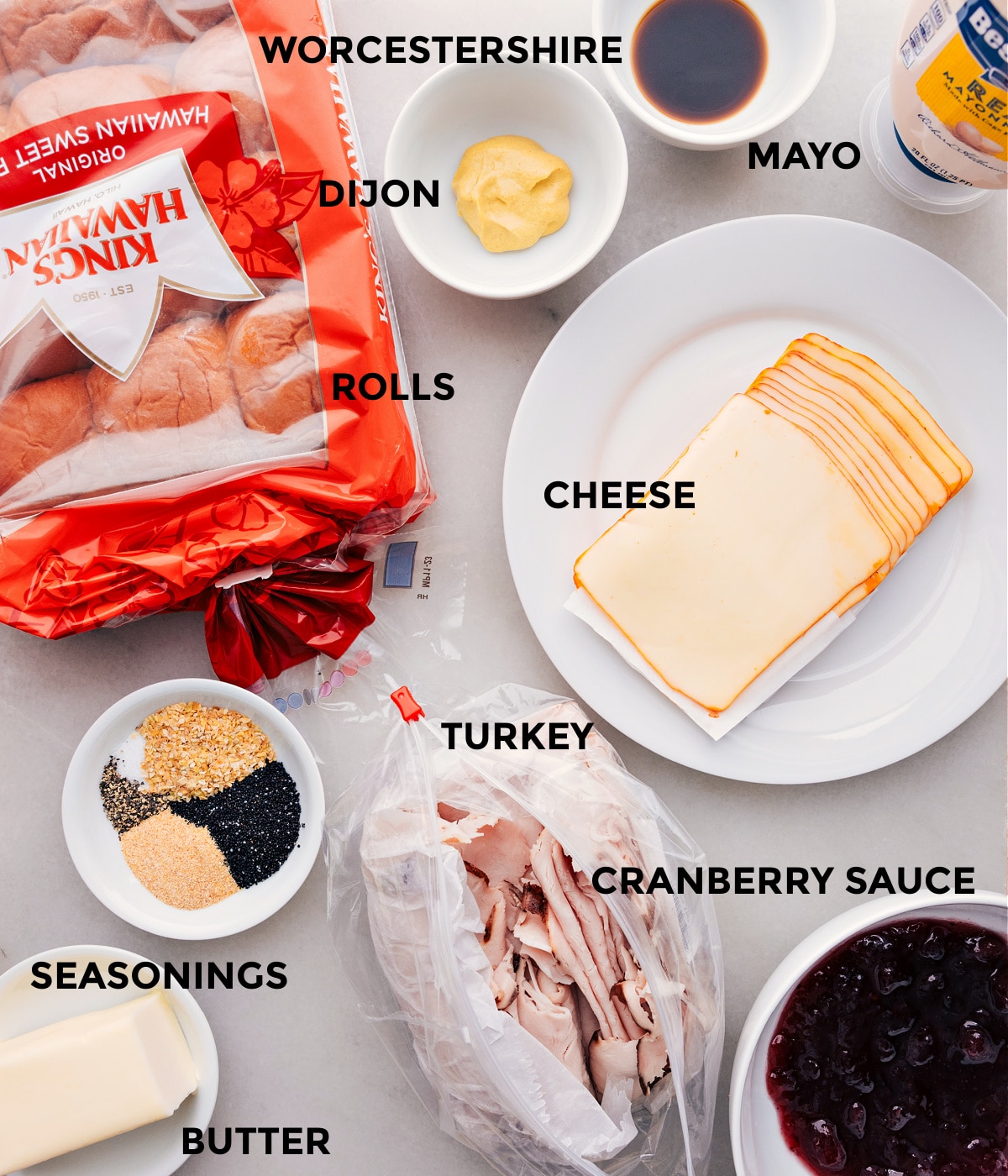 Ingredients In Turkey Cranberry Sliders All the ingredients in this recipe prepped for easy assembly including the rolls. dijon, Worcestershire, mayo, cheese, turkey, cranberry sauce, and butter.