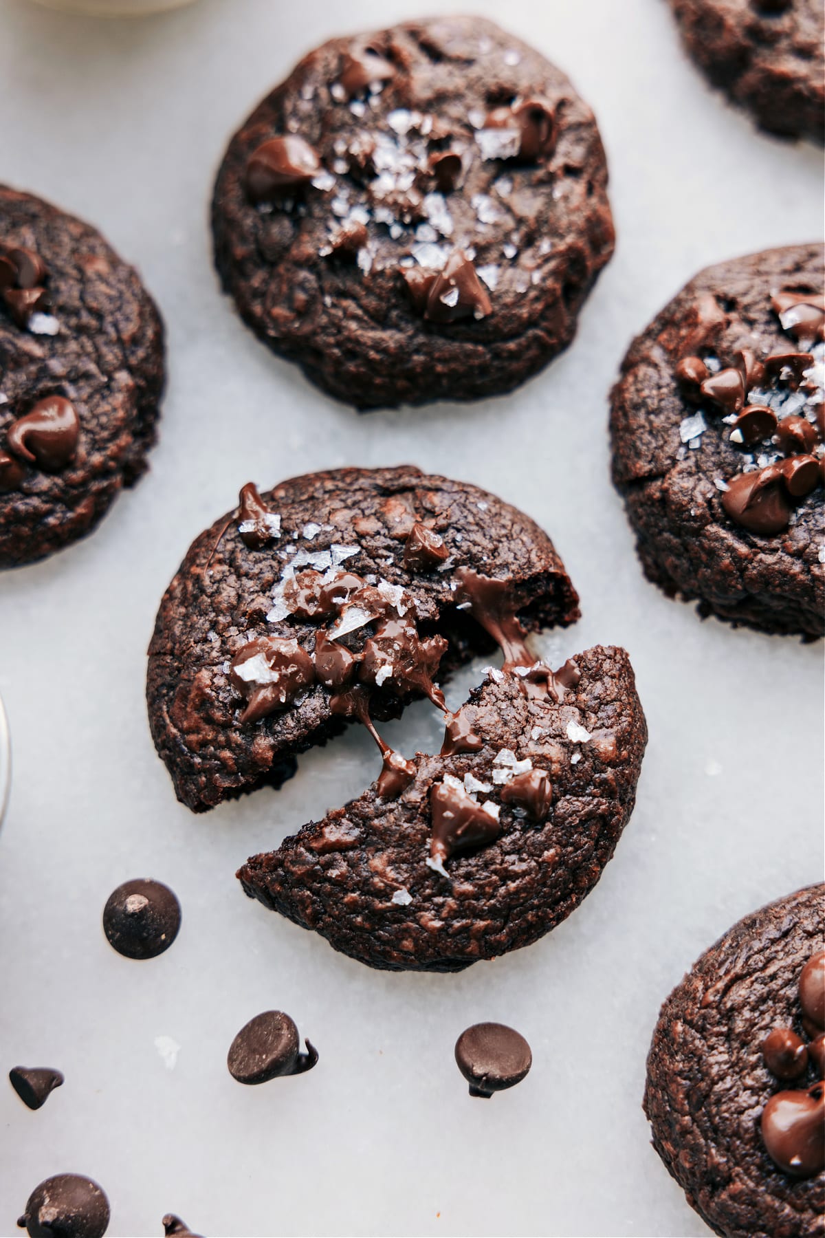 The Best Brownie Cookie Recipe Brownie Cookies recipe on a board freshly baked up with one broken up and chocolate oozing out.