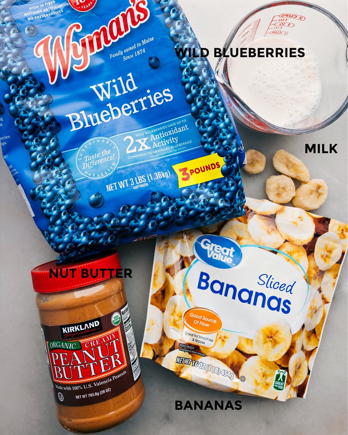 The Simple Four Ingredients In This Blueberry Smoothie The four ingredients: frozen fruit, banana, almond milk, and nut butter prepped out for easy assembly.