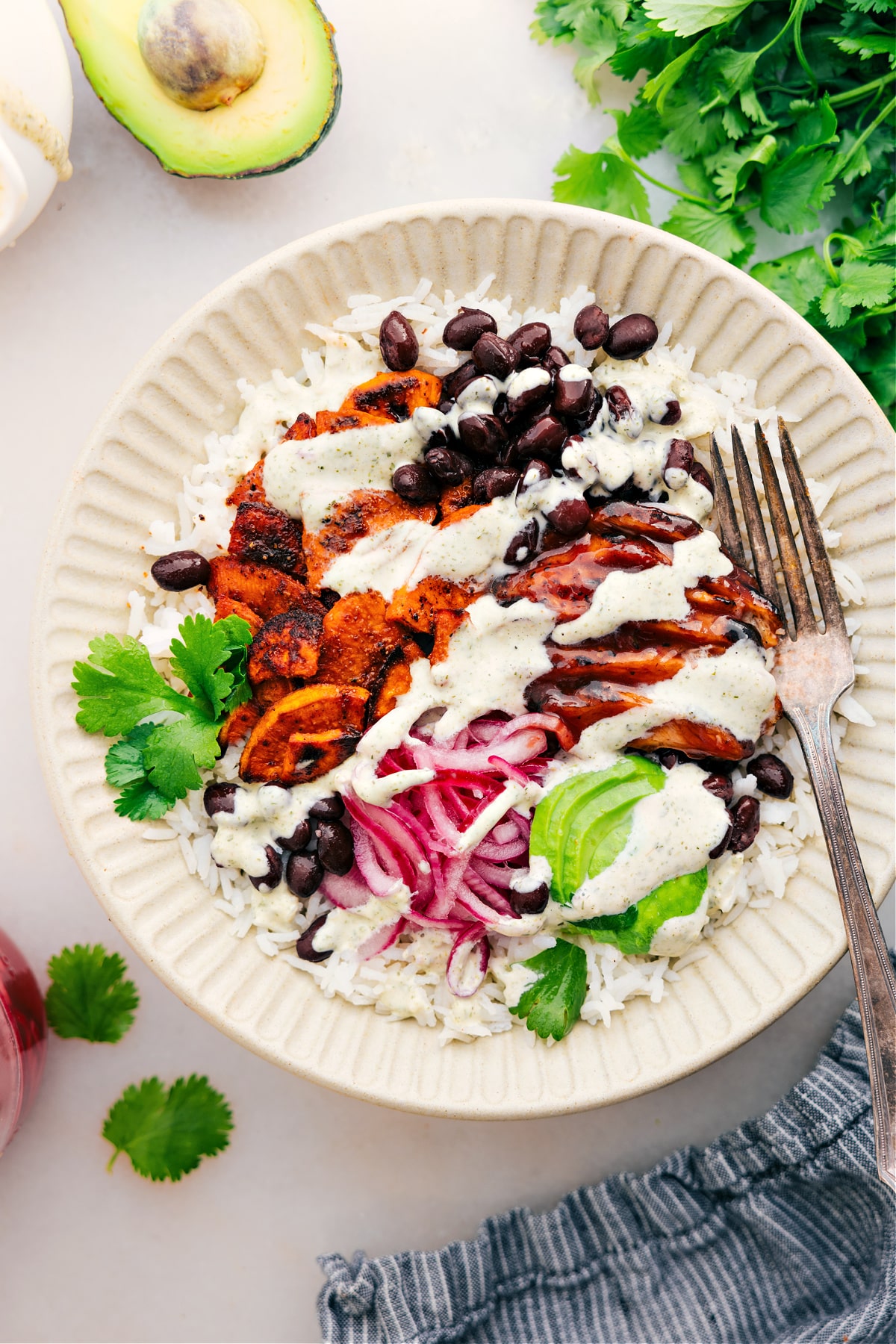 Easy And Delicious BBQ Chicken Rice Bowls Serve the dish with rice, meat, beans, onions, avocado, and a drizzle of green goddess dressing.