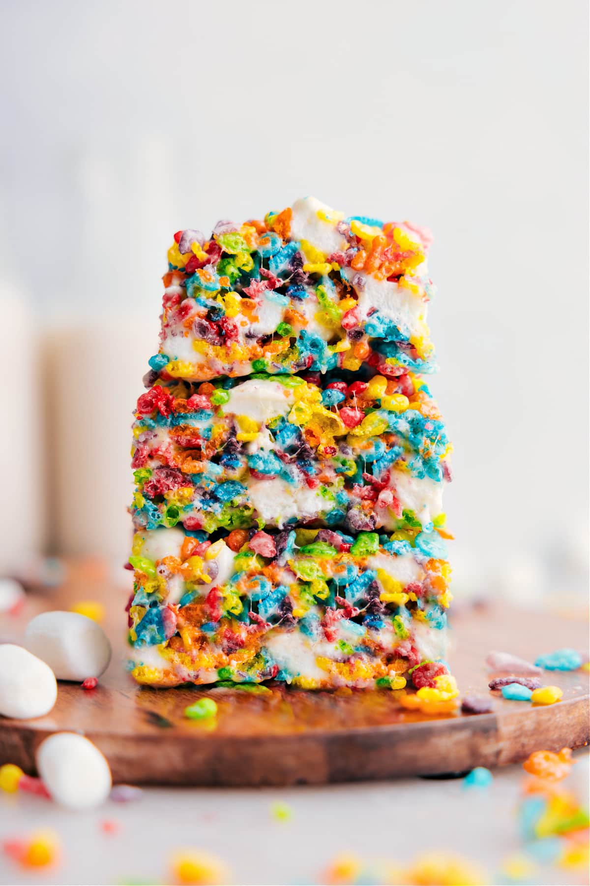 The Best Fruity Pebbles Rice Krispies Treats Recipe Fruity Pebbles Rice Krispies Treats stacked on top of each other showing the gooey desserts.