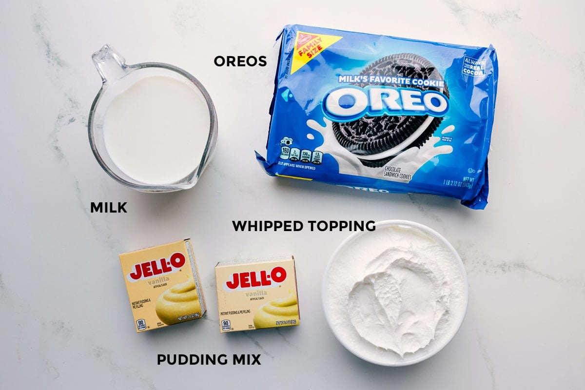 Ingredients In Favorite Icebox Cake Ingredients prepped for easy assembly, including Oreos, milk, whipped topping, and pudding mix.