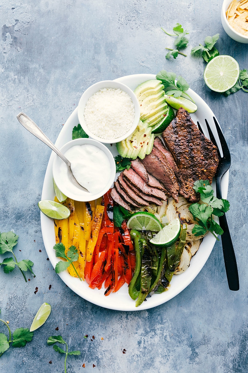 Steak Fajita Recipe Is Fresh And Flavorful Steak Fajita Recipe with all the mixings like fresh avocado, lime, cilantro, sour cream, and cheese.