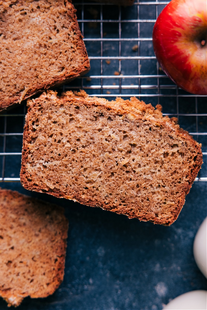 This Apple Bread Recipe is one of our all-time favorite quick breads! It's sweet, tender, and moist with shredded apples in every bite. This loaf is warmly spiced with a hint of cinnamon and a touch of nutmeg. Recipe via chelseasmessyapron #fall #quick #easy #simple #familyfriendly #kidfriendly #treat #applebread #recipe Overhead image of the apple bread recipe