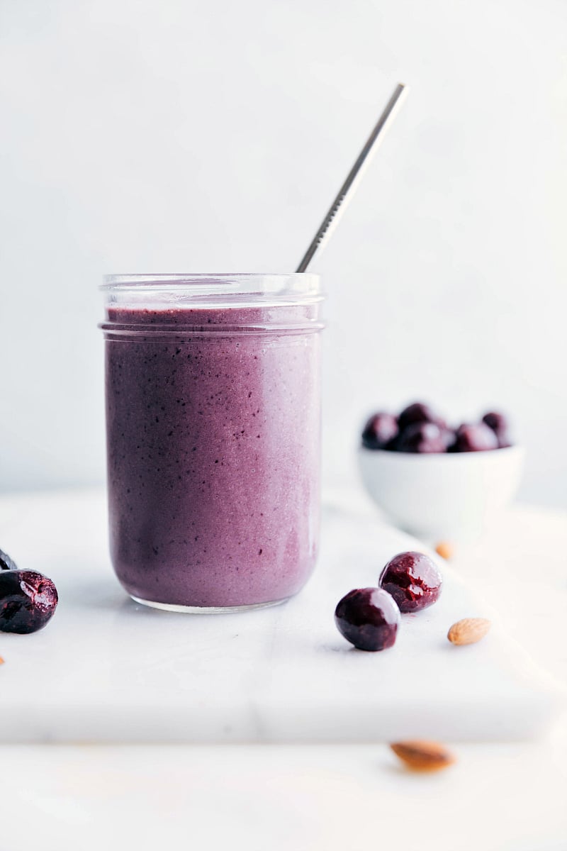 A delicious cherry smoothie with a straw in it, showcasing a vibrant color and smooth texture.