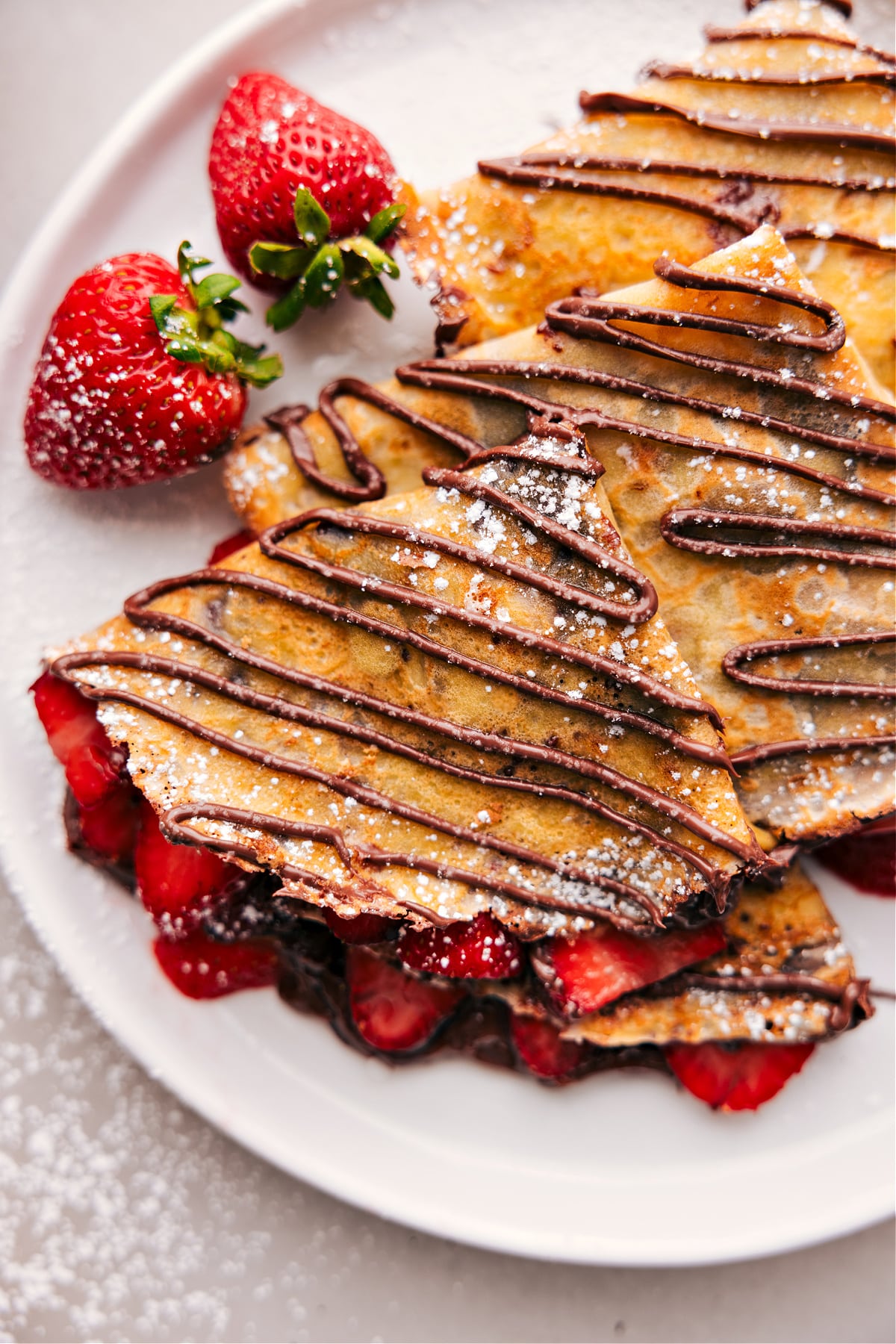 The finished dessert of warm Nutella crepes expertly cooked to achieve the perfect texture, filled with fresh strawberries and Nutella.