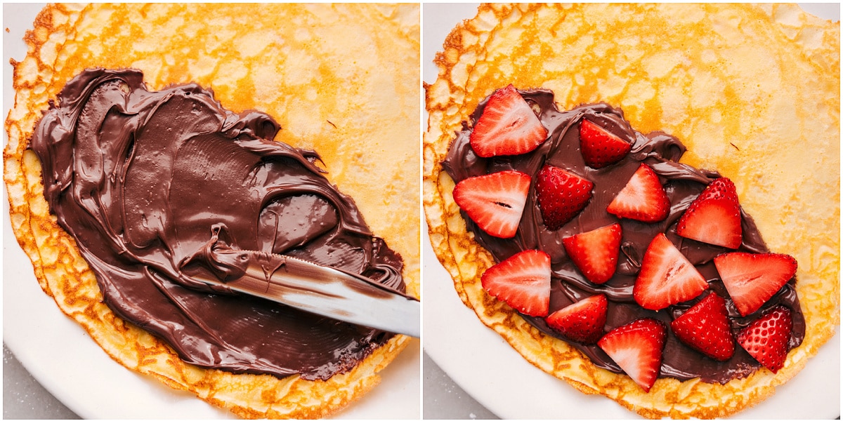 Spreading Nutella on freshly made crepes and generously topping them with sliced strawberries.