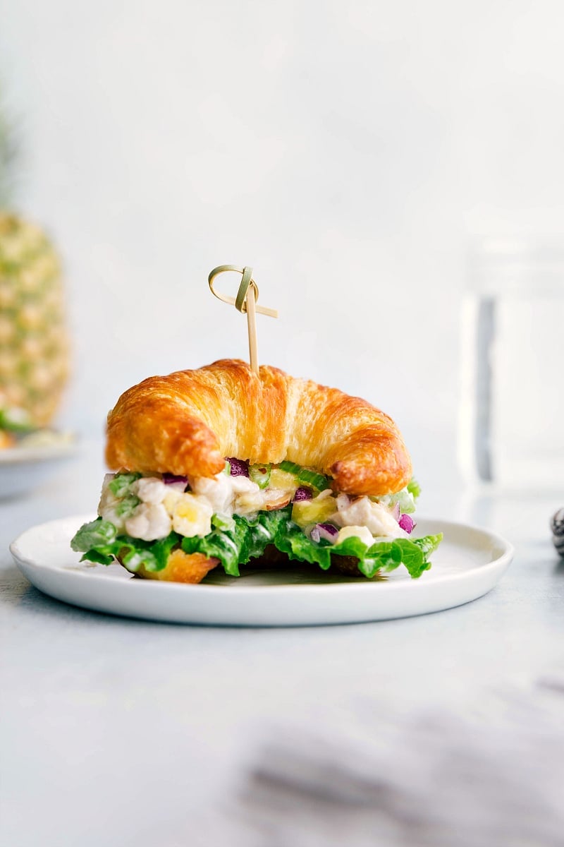 Pineapple chicken salad on a croissant, overflowing with flavorful ingredients, creating the perfect combination of savory and sweet.