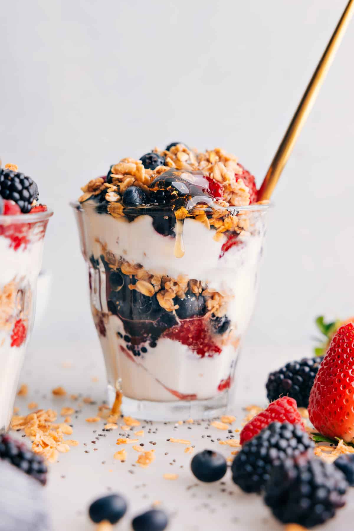Layered yogurt parfait in a cup, showcasing layers of creamy yogurt, fresh fruit, drizzles of honey, and crunchy granola on top.