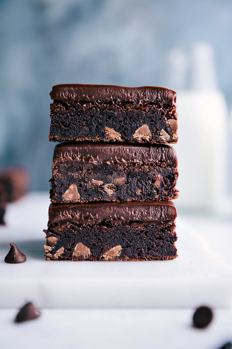 Three gluten-free brownies stacked on top of each other, displaying a fudgy, rich interior packed with gooey chocolate chips, ready to be enjoyed.
