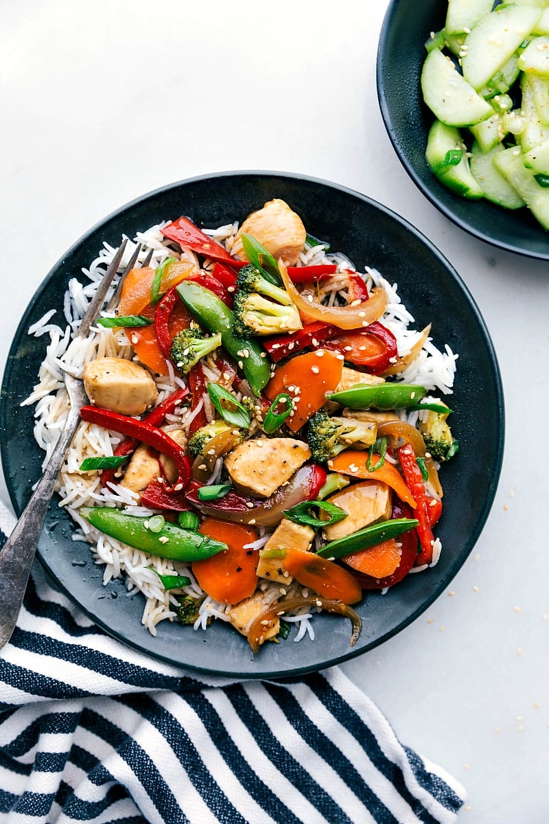 Stir Fry Delight - Chicken Over Rice, Ready for Enjoyment Flavor-packed stir fry chicken served in a bowl over a bed of rice, ready to be enjoyed.