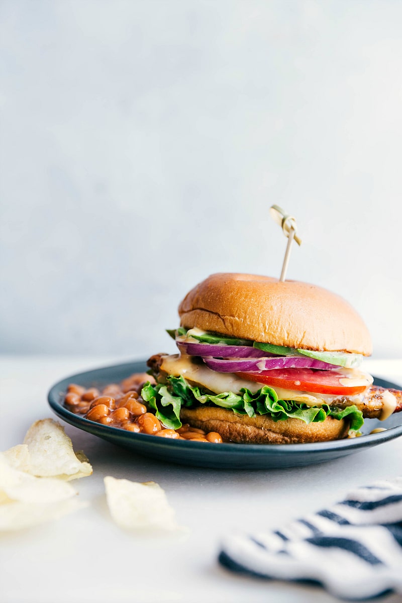 Chicken Burger Meal with Baked Beans A chicken burger on a plate accompanied by a side of baked beans, presenting a delicious and satisfying meal, ready for enjoyment.