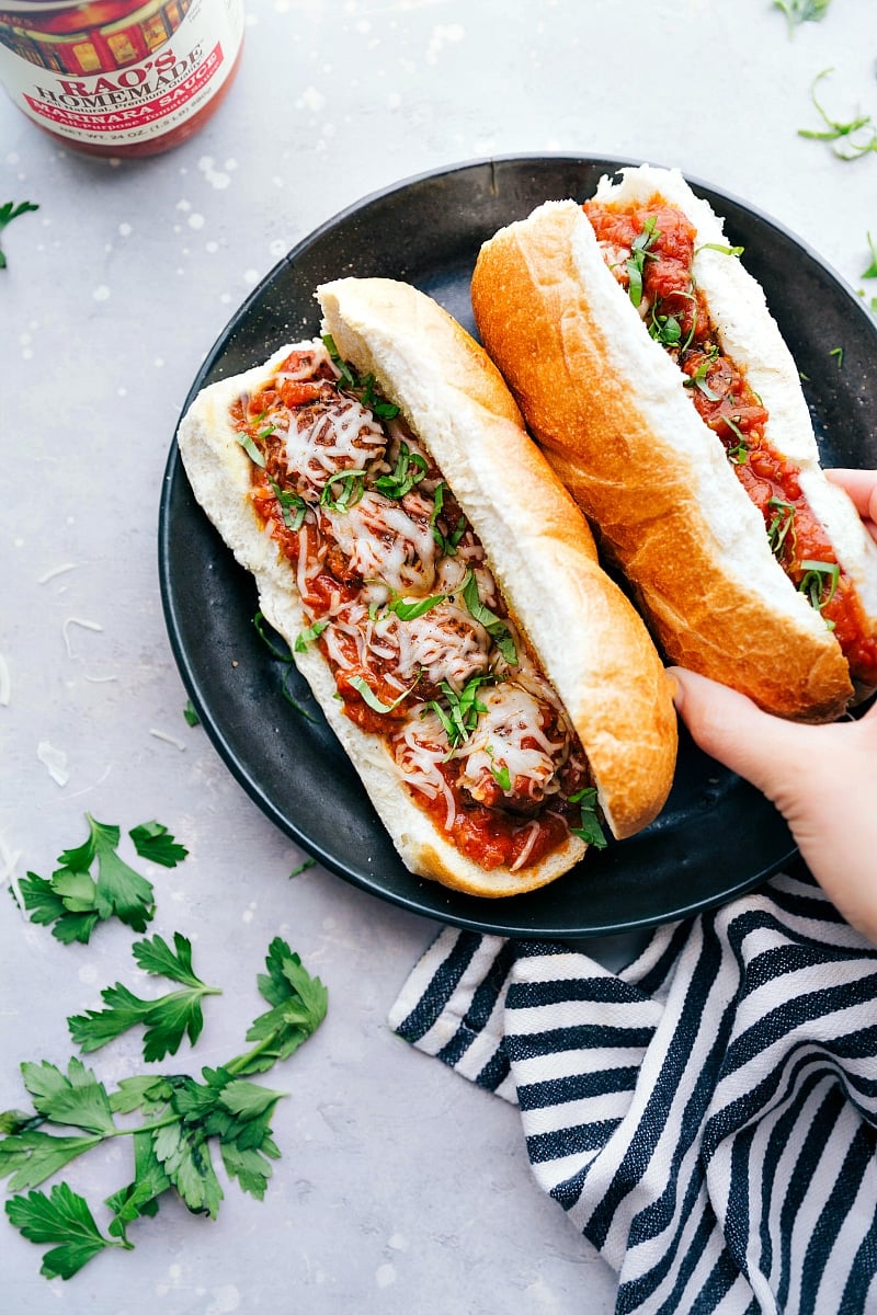 Plate of Delicious Meatball Subs A plate filled with mouthwatering meatball subs, where the buns are overflowing with meat and flavor, topped with cheese and fresh herbs, all set for a delightful meal.