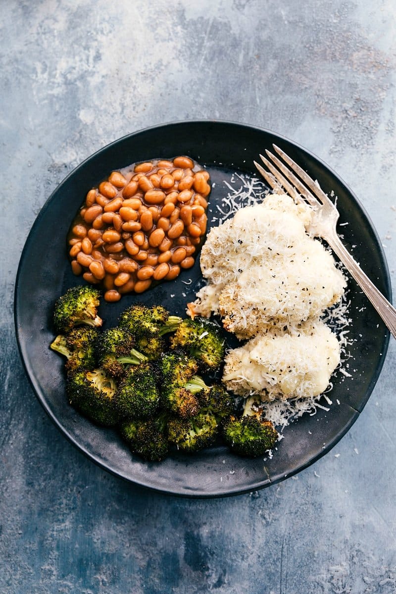 Delicious Baked Alfredo Chicken with Sides of Beans and Baked Broccoli Baked alfredo chicken served on a plate with beans and baked broccoli.