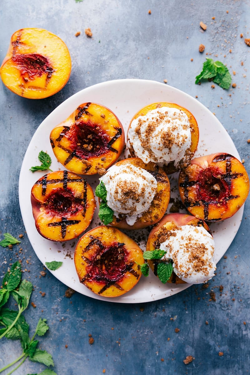 Grilled Peaches Dessert - Sweet and Fruity Delight with Ice Cream and Mint Grilled peaches with ice cream and fresh mint on top - a sweet and fruity treat.