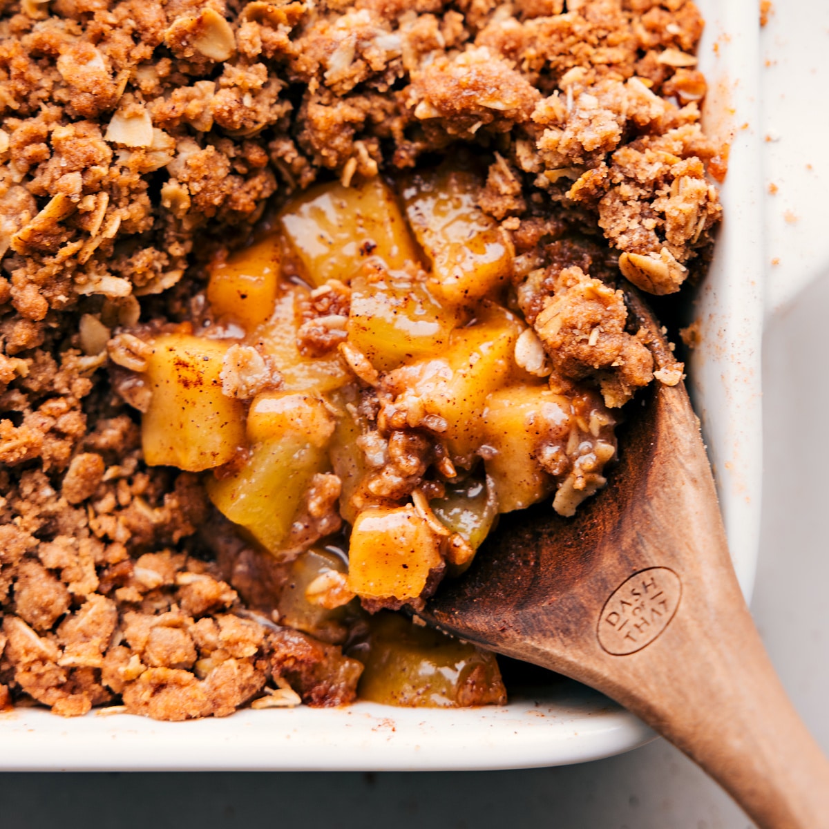 Freshly Baked Apple Crumble Spoonful - Cinnamon and Fruity Delight A large spoonful of the freshly baked dessert, showcasing the cinnamon and fruity interior, ready to be savored.