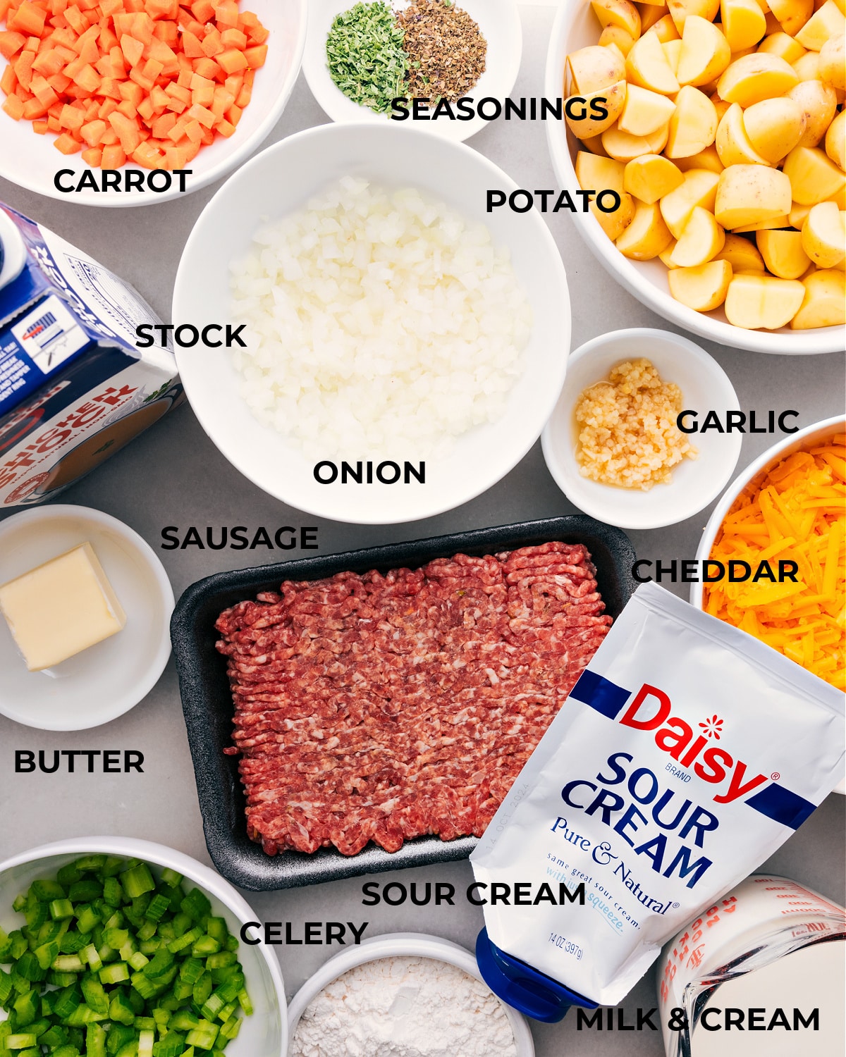 Ingredients In Sausage Potato Soup Recipe All the ingredients for this recipe are prepped, including potatoes, seasonings, veggies, meat, stock, butter, and sour cream, making assembly easy.