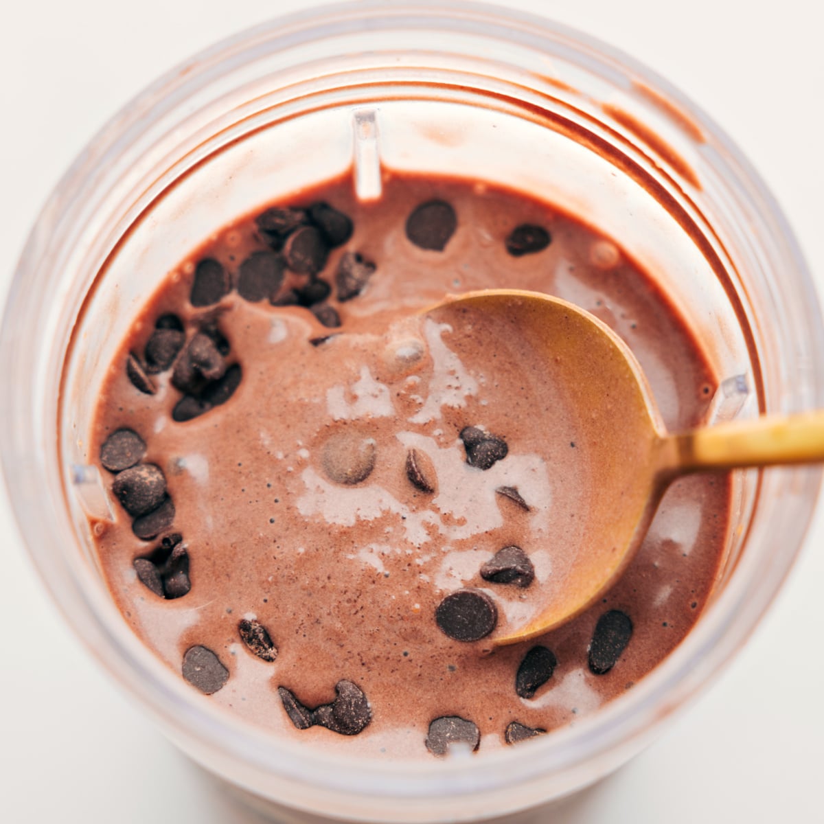 6-Ingredient Chocolate Protein Shake Recipe Spoonful of the delicious and creamy chocolate protein shake with chocolate chips on top for an extra delicious treat.