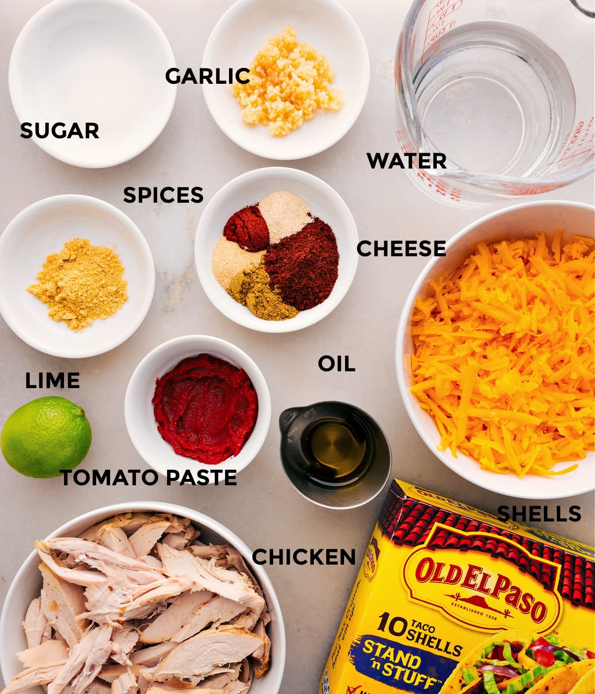 Ingredients In Rotisserie Chicken Tacos This recipe's ingredients are prepped for easy assembly: meat, water, cheese, shells, seasonings, tomato paste, lime, garlic, and sugar.