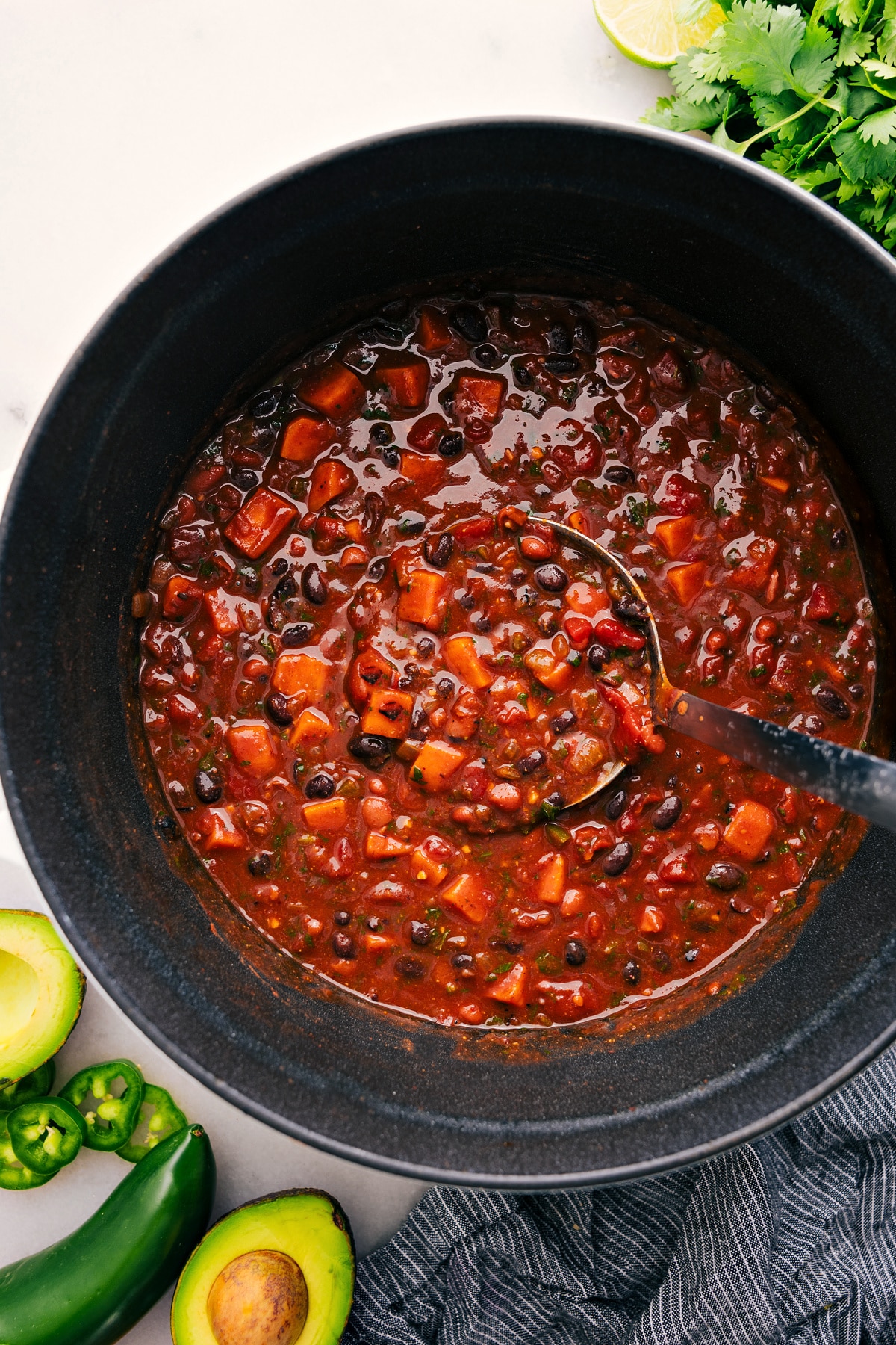 The Best Sweet Potato Chili Recipe A big scoop of Sweet Potato Chili coming out of the pot.