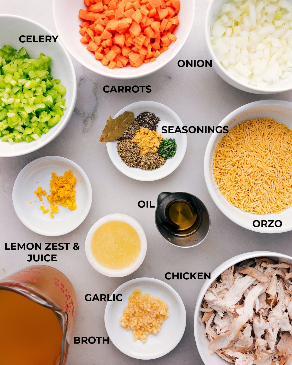 Preparation Perfection: Ingredients Laid Out for Zesty Lemon Chicken Orzo Soup Assorted fresh ingredients for lemon orzo chicken soup displayed, including lemon, chicken, orzo pasta, vegetables, and herbs.