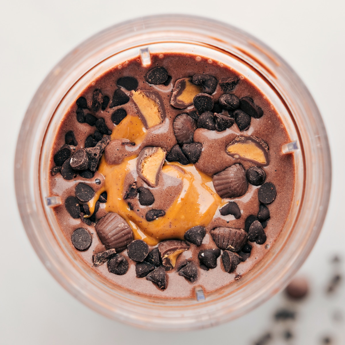 Chocolate Peanut Butter Protein Shake Mix-Ins Chocolate peanut butter protein shake with fun toppings like chocolate chips and reeses to give you a high protein treat.