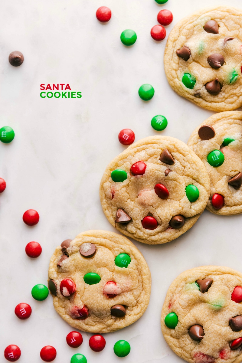 "Festive Santa Cookies with Red and Green Chocolate Candies - Perfect for Holiday Celebrations A collection of santa cookies, adorned with festive red and green chocolate candies.
