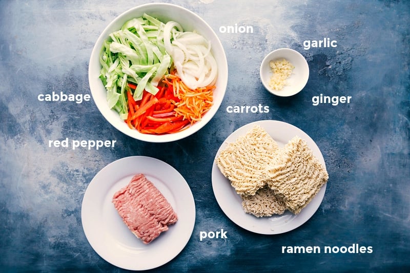 Key Ingredients for Preparing Egg Roll Noodles Recipe Assortment of ingredients for egg roll noodle recipe, including cabbage, red pepper, onion, carrots, ramen noodles, ground pork, garlic, and ginger.