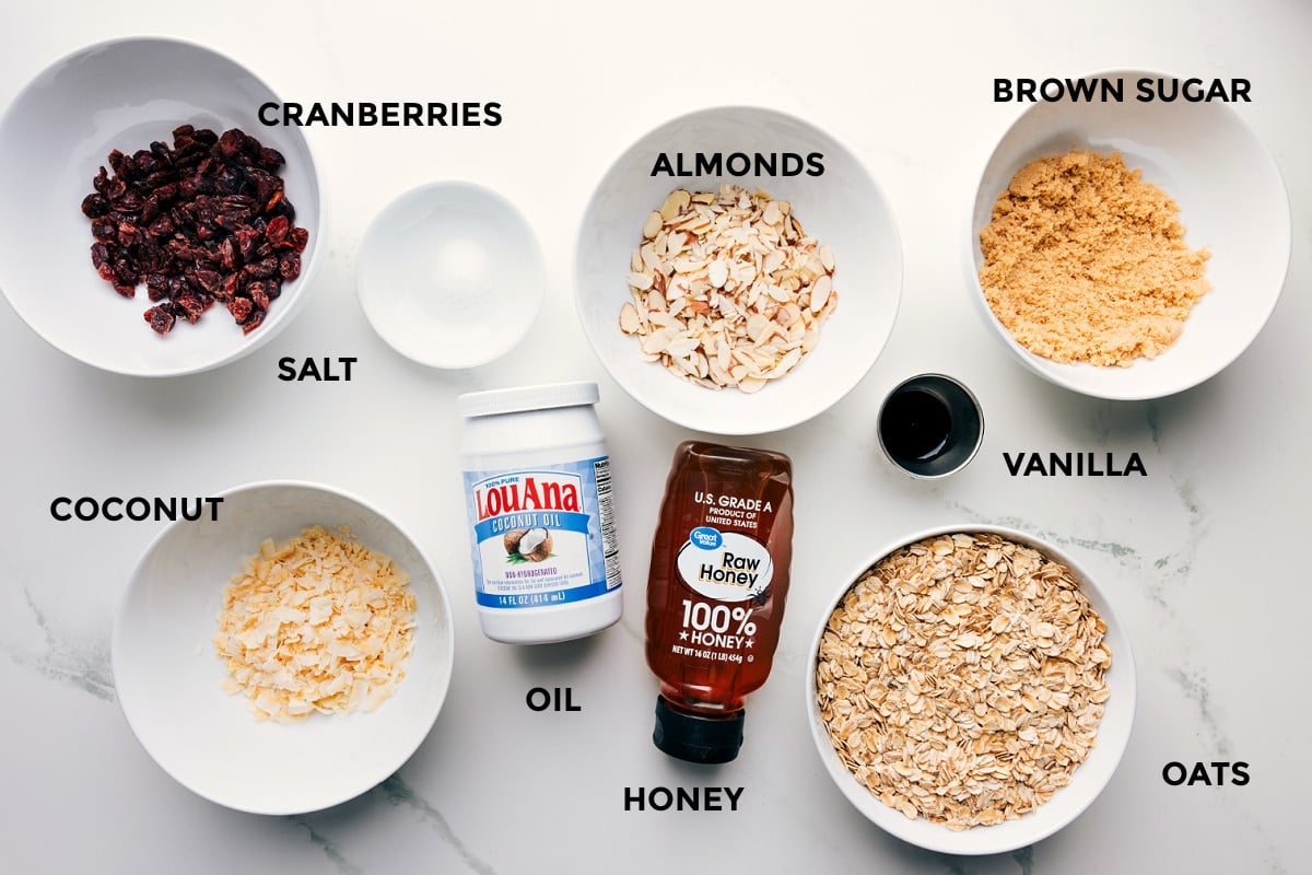 Ingredients In Honey Almond Granola All the ingredients for Honey Almond Granola prepped and ready to assemble: cranberries, salt, almonds, brown sugar, vanilla, oats, honey, oil, and coconut.