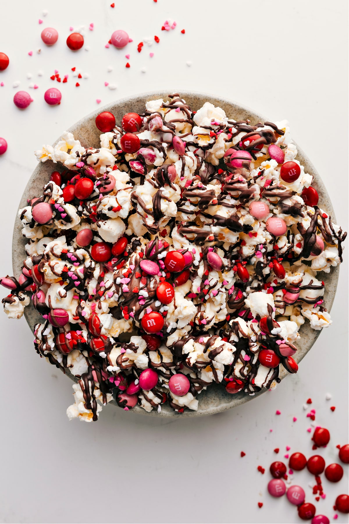 Super Simple And Adorable Valentine's Popcorn Valentine's Popcorn in a bowl with M&M's and sprinkles on top.
