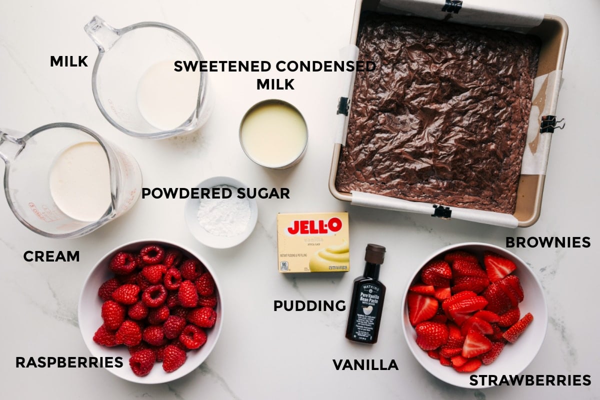Ingredients In This Brownie Trifle All the ingredients in this recipe prepped out for easy assembly including the cream, milk, raspberries, powdered sugar, sweetened condensed milk, pudding, vanilla, strawberries, and brownies.
