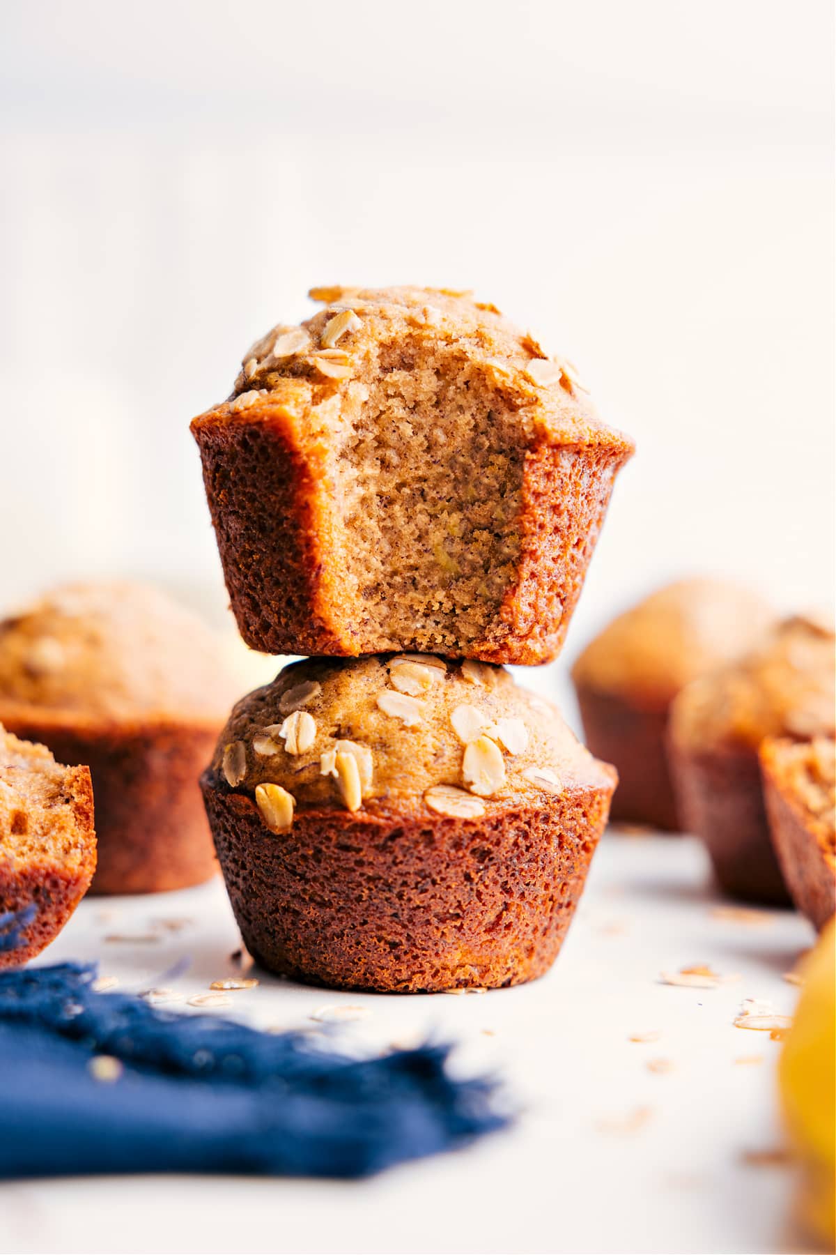 The Best Healthy Banana Muffins Recipe Healthy Banana Muffins stacked with a bite taken out of the top one, revealing the moist and delicious interior.