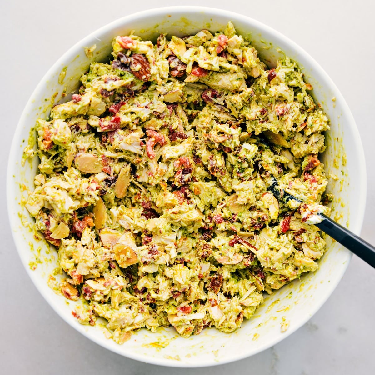 How To Make Pesto Chicken Salad Ingredients all mixed together in a large bowl.
