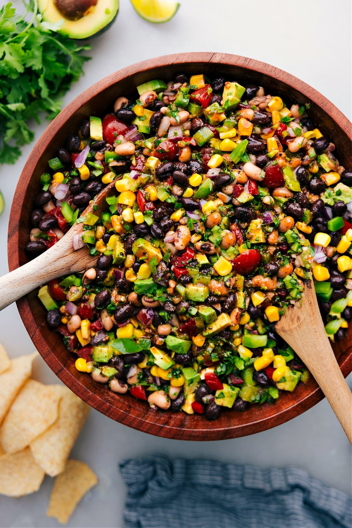Favorite Cowboy Caviar Recipe A big bowl of the cowboy caviar with two wooden spoons in it to be served up.