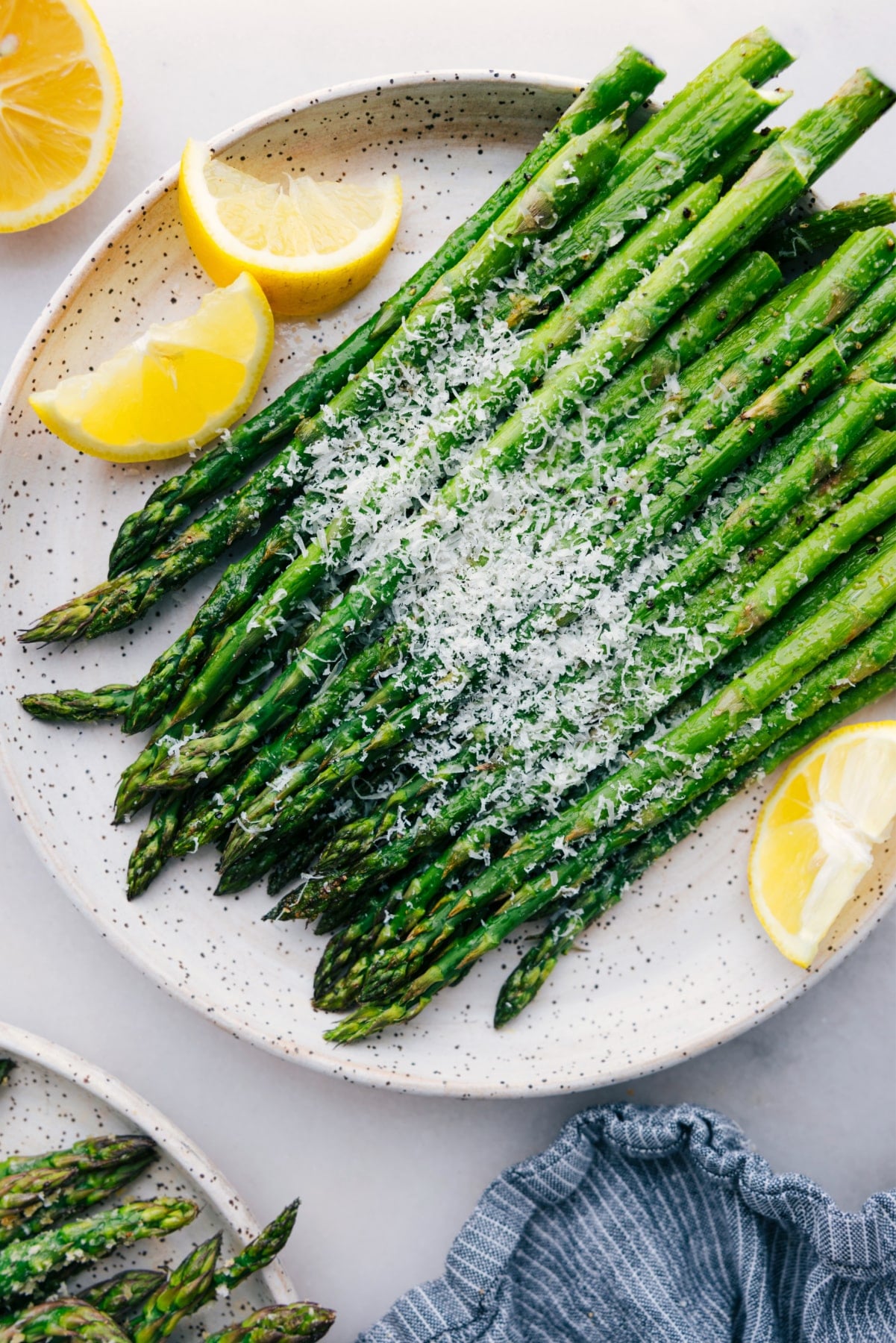 Easy roasted asparagus recipe with fresh parmesan cheese and lemon slices.