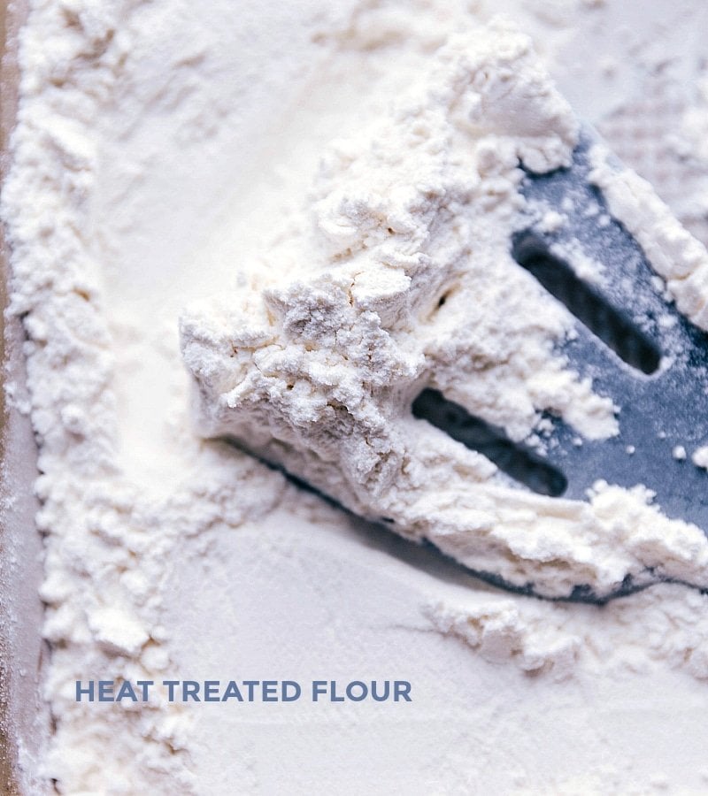 Heat Treatment of Flour for Safe Raw Consumption in Edible Dough Flour spread on a baking sheet being heat-treated in an oven, a crucial step to ensure the dough is safe to consume raw.