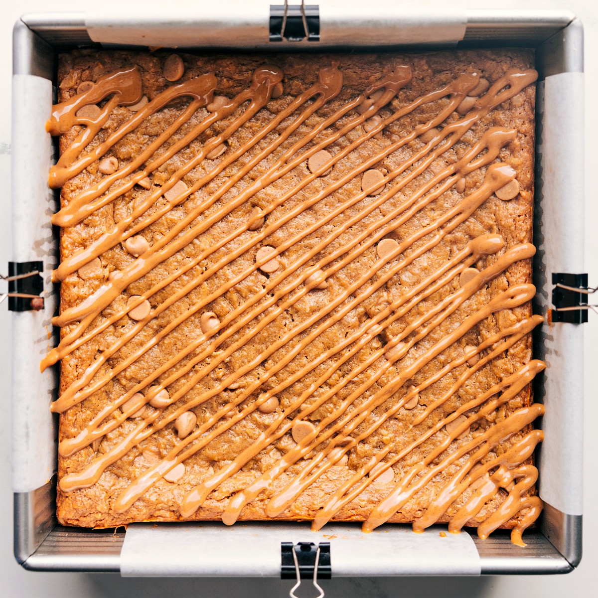 This Oatmeal Bars Recipe Is Irresistibly Good And Kid-Friendly The baked up treat still in the pan with a drizzle of melted peanut butter chips on top.